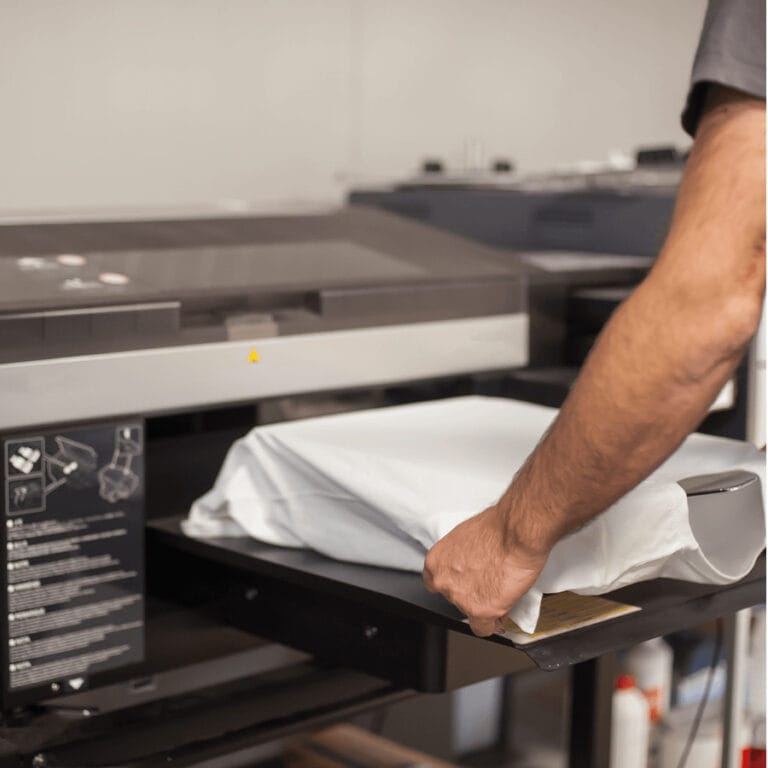 T-shirt being placed onto a DTG printer platen ready for printing.
