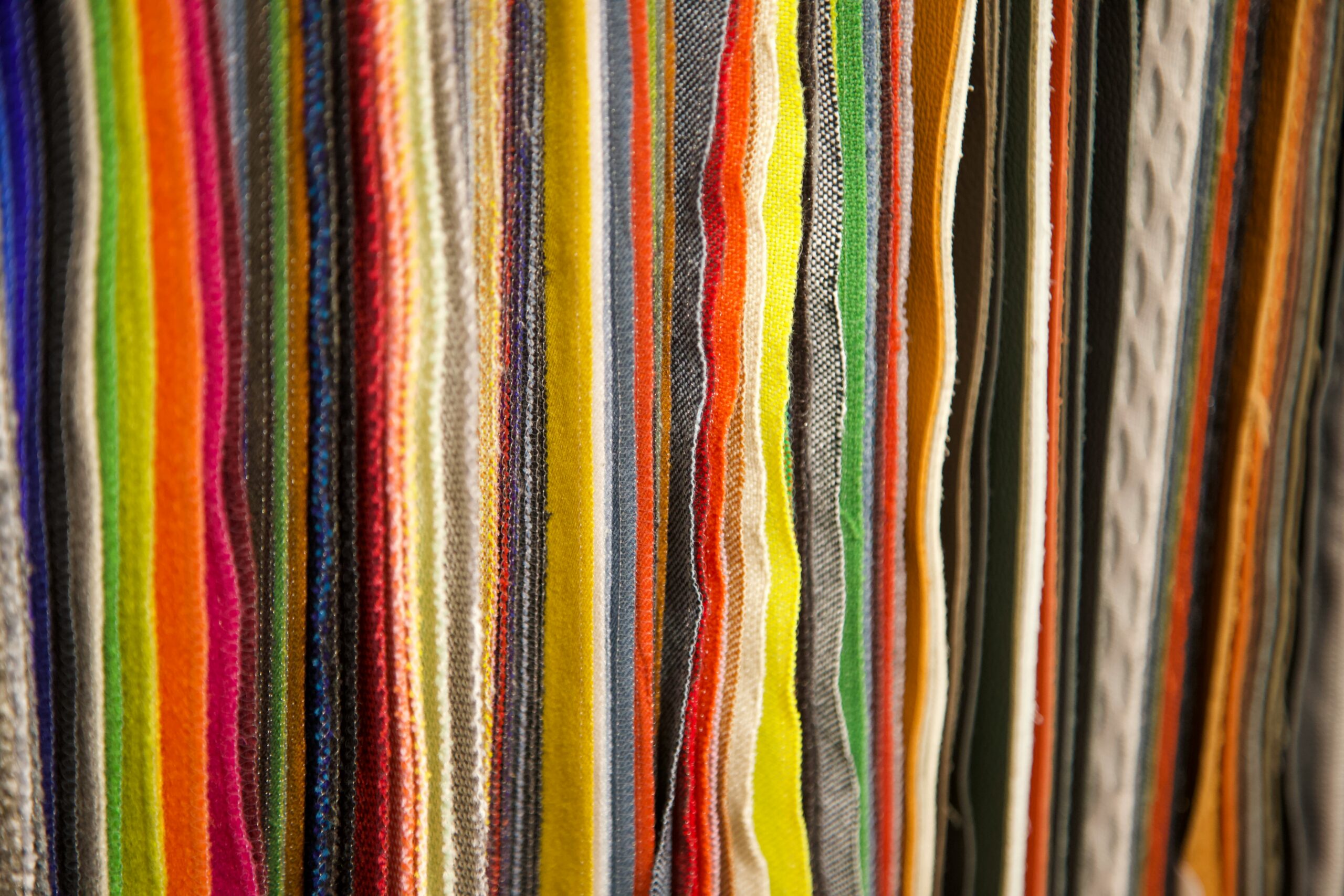 A range of coloured textiles and fabrics.